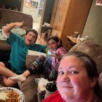 Angie takes a selfie with her son and daughter as they sit together in the living room watching election results on election night.