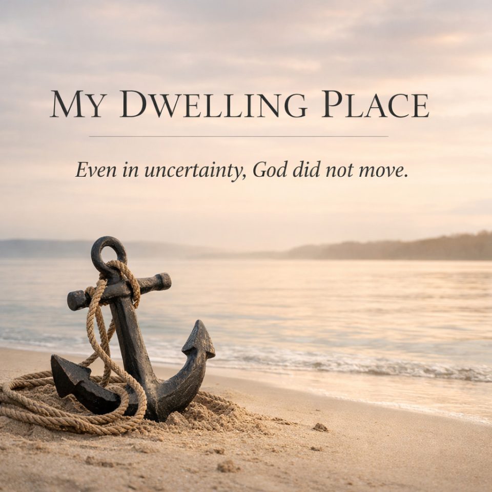 Anchor resting on a sandy beach beside calm water beneath a soft morning sky, with the words “My Dwelling Place” and “Even in uncertainty, God did not move.”