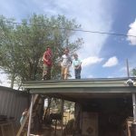 Three children standing on the roof of the carport at the Country House