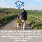 A father and young son walk together down a hill through the countryside in their German village