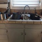 Kitchen sink filled with dirty pots, pans, and dishes waiting to be washed.