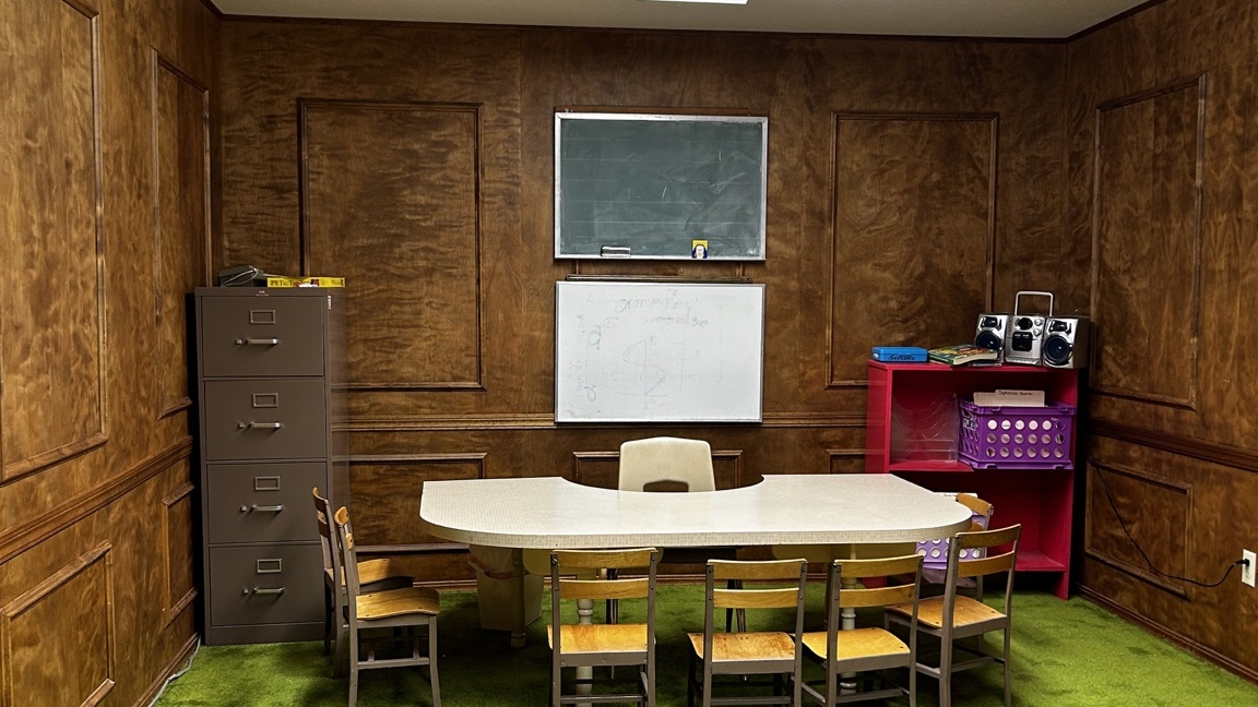 An empty Bible classroom with child-sized chairs arranged around a table, ready for students.